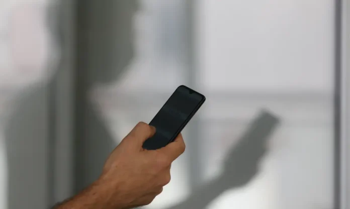 Pessoa utilizando um smartphone em matéria sobre roubos e furtos de celulares registrados no Brasil em 2025.